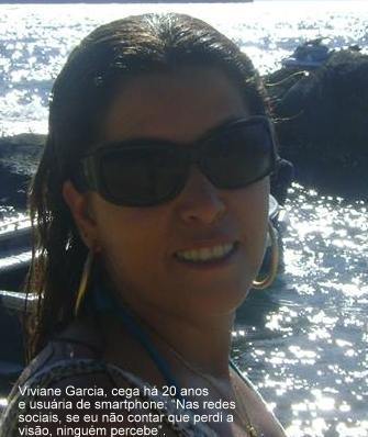 Descrição de Imagem: Viviane aparece à beira mar, de óculos escuros e cabelos castanhos, ao fundo se vê pequenos barcos no mar. Texto: Viviane Garcia, cega há 20 anos e usuária de smartphone diz: Nas redes sociais, se eu não contar que perdi a visão, ninguém percebe.