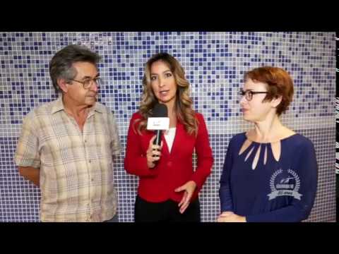 Dr. Kal, à esquerda e Ivone Santana à direita. No centro uma repórter com um microfone na mão entrevista ambos.