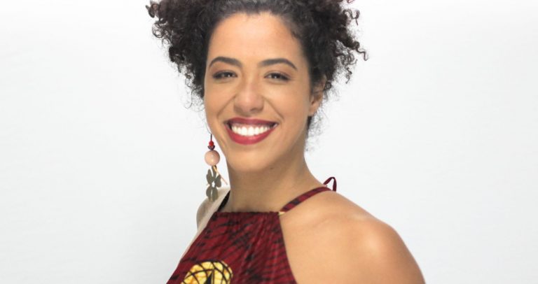 foto de Telíria Petrone. Ela está sorrindo, tem a pele negra e cabelos curtos encaracolados.