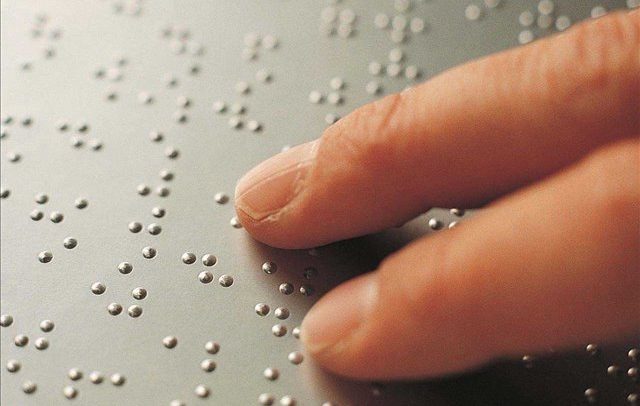 foto de dois dedos "lendo" texto em braile.