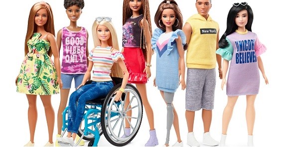 sete bonecas Barbies aparecem lado a lado na foto de divulgação da série Fashionistas 2019. Em destaque a Barbie em sua cadeira de rodas azul e a Barbie com prótese total na cor cinza clara na perna direta