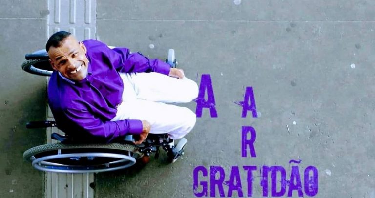Em fundo cinza e roxo, a capa do CD “A arte da gratidão” mostra uma imagem aérea do compositor Carlinhos sentado na sua cadeira de rodas. Ele posa para a fotografia sorrindo