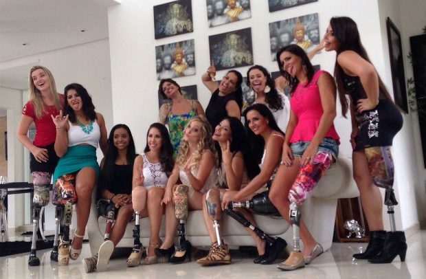 fotografia mostra 12 modelos com prótese nas pernas. Elas sorriem ou fazem caretas e gestos divertidos