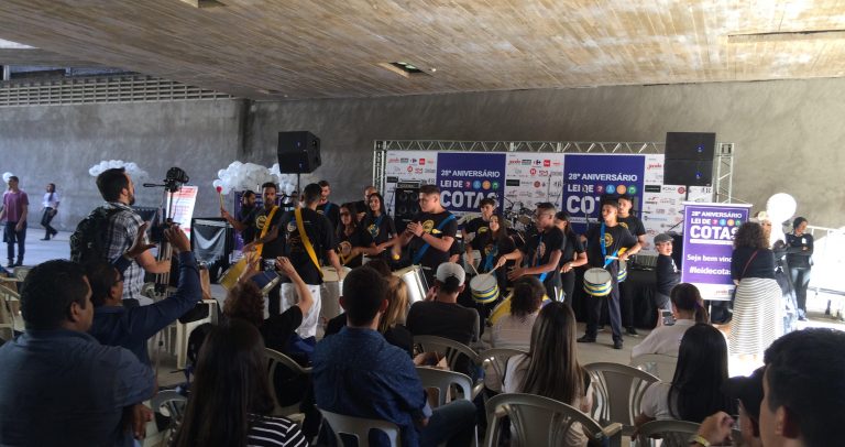 fotografia mostra músicos do Grupo de Percussão do Nurap tocando junto ao público. No fundo, o palco.