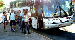 uma fila de pessoas ao lado de um ônibus com a porta aberta