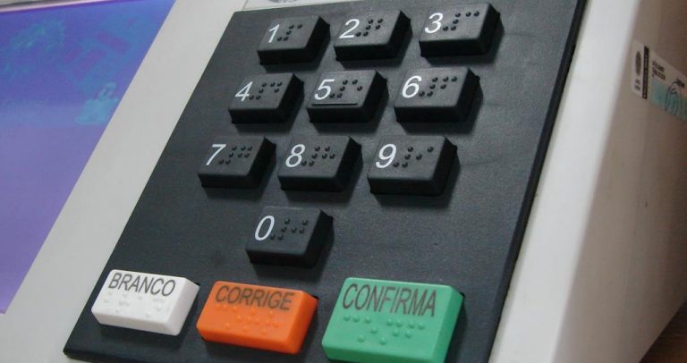 foto de uma urna eletrônica, com foco no teclado, onde aparecem os botões numéricos de 0 a 9 e os botões que branco, para votar em branco, corrige, que é de cor vermelho, e confirma, que é verde.
