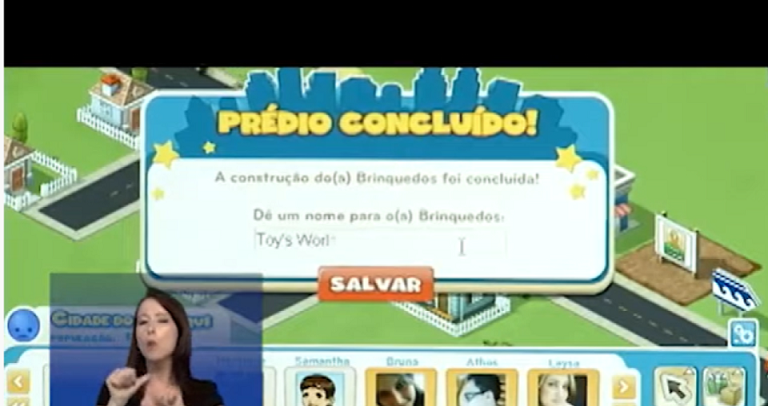 tela de um game, em um fundo verde há uma mensagem escrita: prédio concluído: A construção dos brinquedos foi concluída. No canto esquerdo, há uma mulher fazendo a interpretação de libras, ap lado há quatro figuras de avatares do jogo