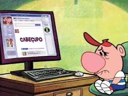 desenho de um menino encolhido na cadeira e com expressão muito triste, lendo pelo computador que está à sua frente, dentro da rede social, a palavra escrita em letras enormes "cabeçudo".