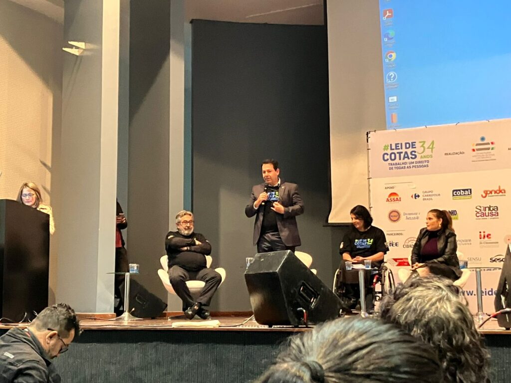 Marcus Mello, superintendente do Trabalho, está de pé no palco, entre Dr. Kal e Anna Paula Feminella.