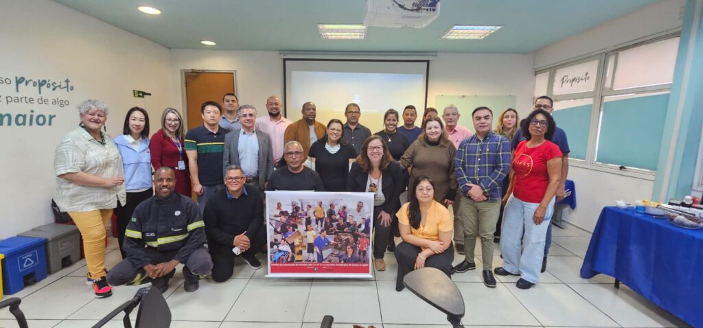foto do grupo de participantes, que está reunido na frente do auditório do evento.